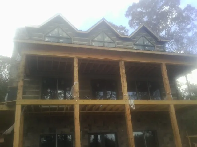 Dormers and porch framing on a large log home under construction — Roof Coating work by our crew in Modesto
