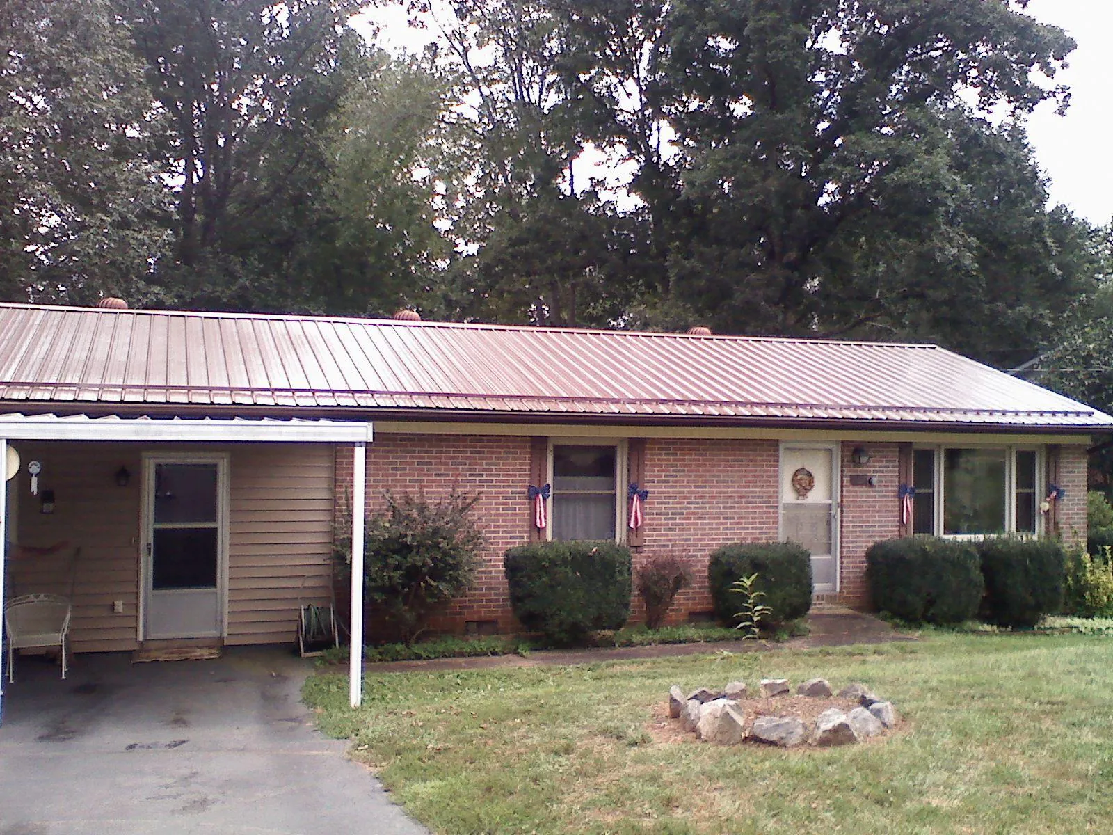 Bronze metal roof and carport on a brick ranch home — Roof Repair work by our crew in Modesto